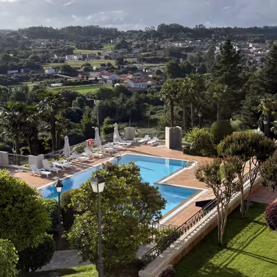Hilltop view of countryside and pool terrace at Hotel Los Abetos in Santiago