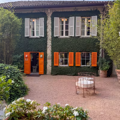 Ivy-covered villa with orange shutters and courtyard garden on Lake Como, Italy