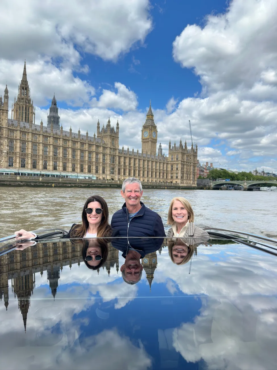 Family on a private boat ride on the Thames with the Houses of Parliament and Big Ben behind