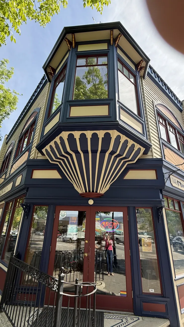 Colorful historic storefront with bold navy and cream trim and large bay windows in a small town