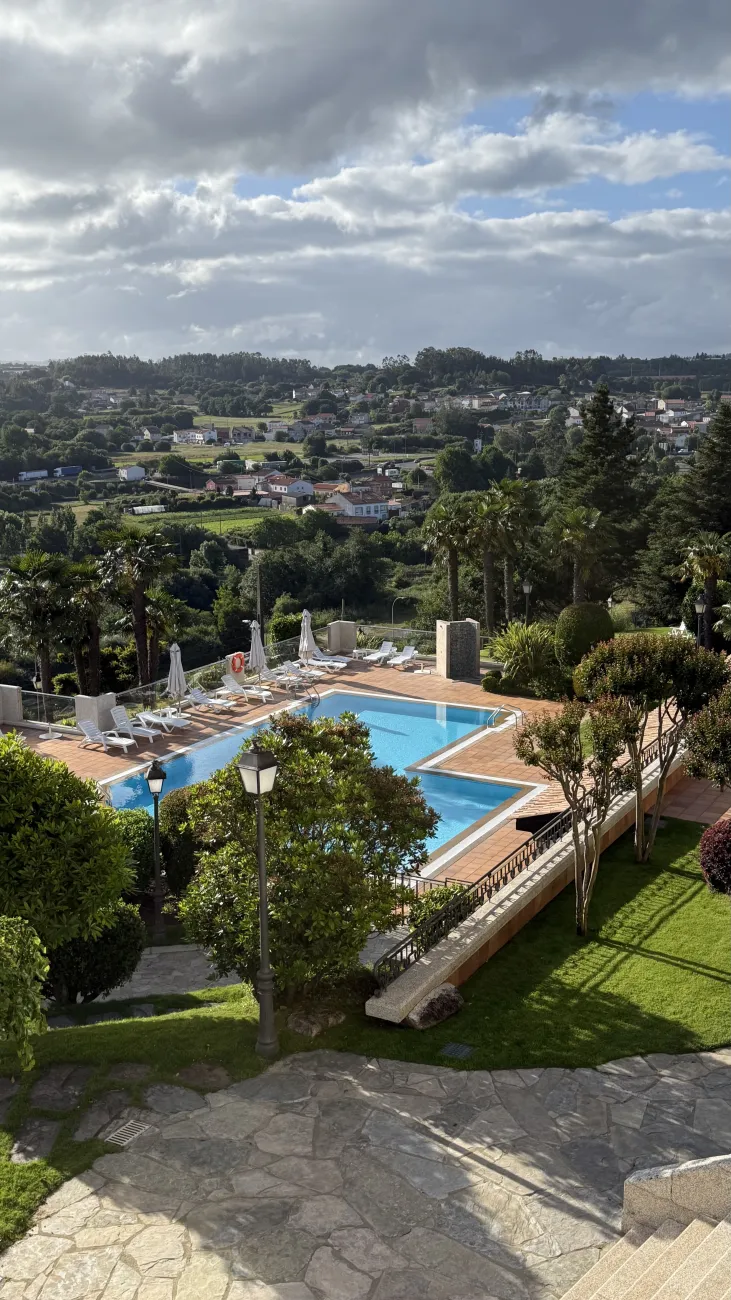 Hilltop view of countryside and pool terrace at Hotel Los Abetos in Santiago
